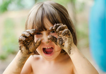 双手沾满泥巴的孩子