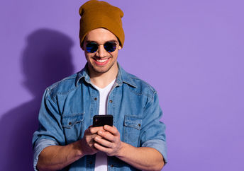 手机的微笑的人使用社会媒体创造积极性。