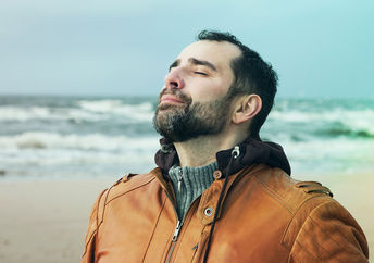 一个男人在海滩上做深呼吸练习。