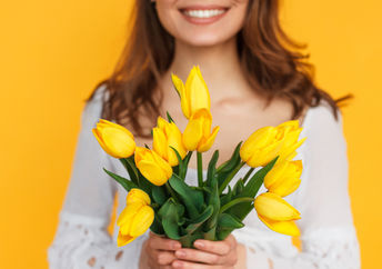一个快乐的女人拿着花来表达善意的照片