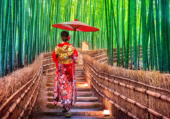 一位穿着和服的日本妇女在竹林中散步，她喜欢锻炼身体。