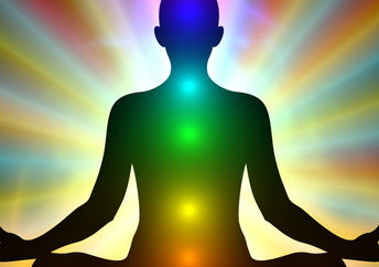 气场的颜色和发光的脉轮在一个正在冥想的人身上。