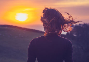 一个正念的女人，怀着敬畏的心情散步，欣赏日落